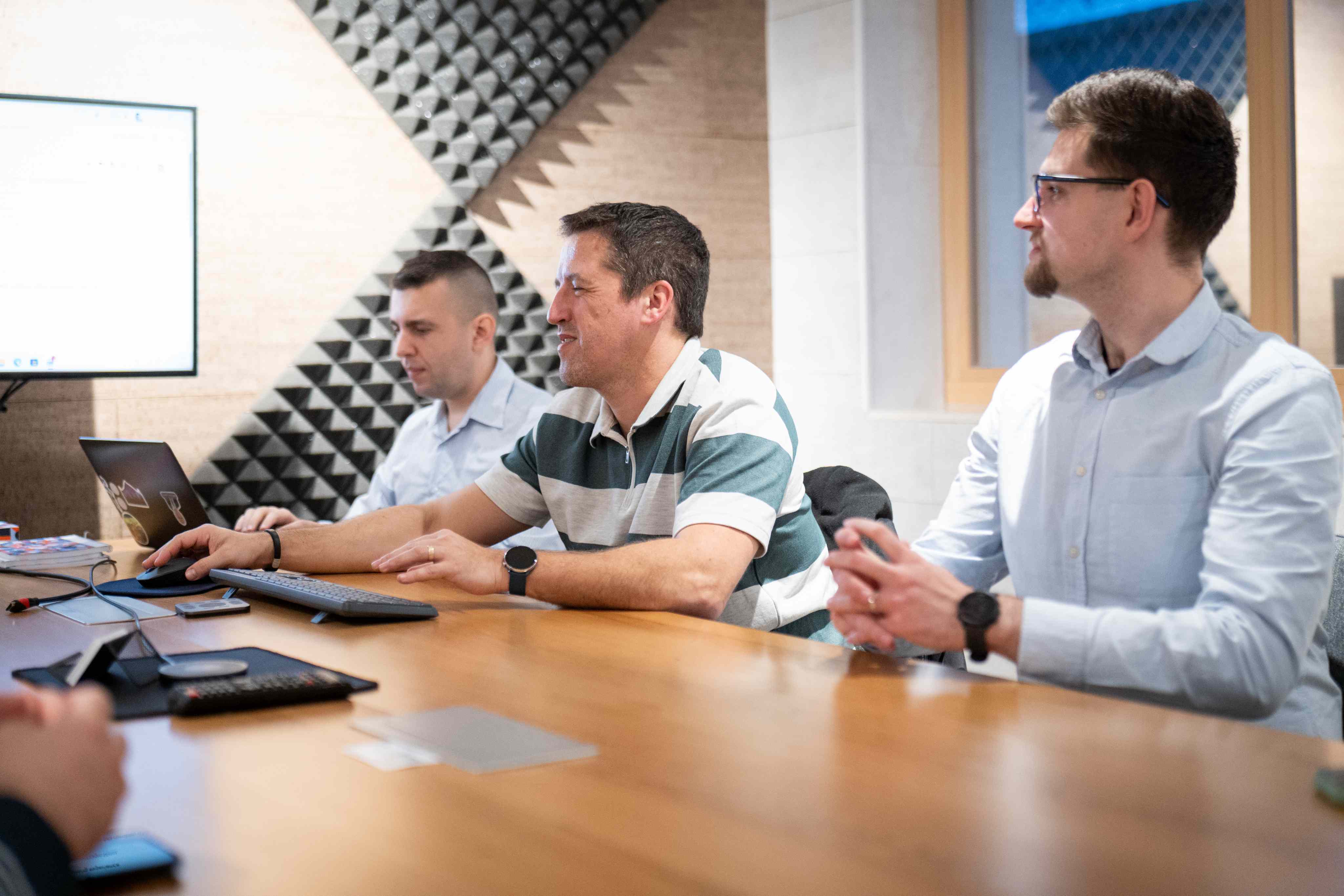 Three colleagues collaborating at a workstation