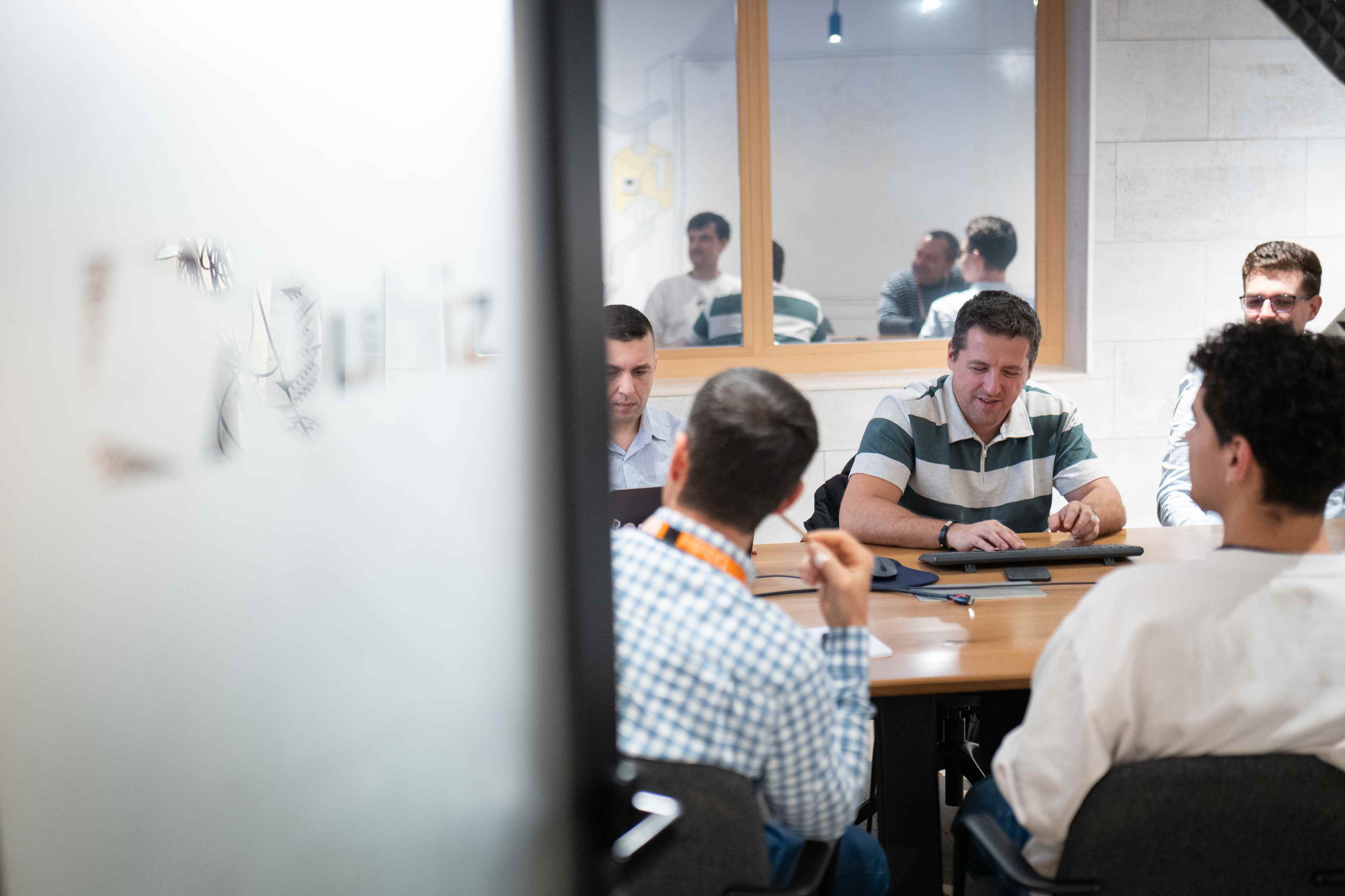 Team meeting viewed through a glass studio partition